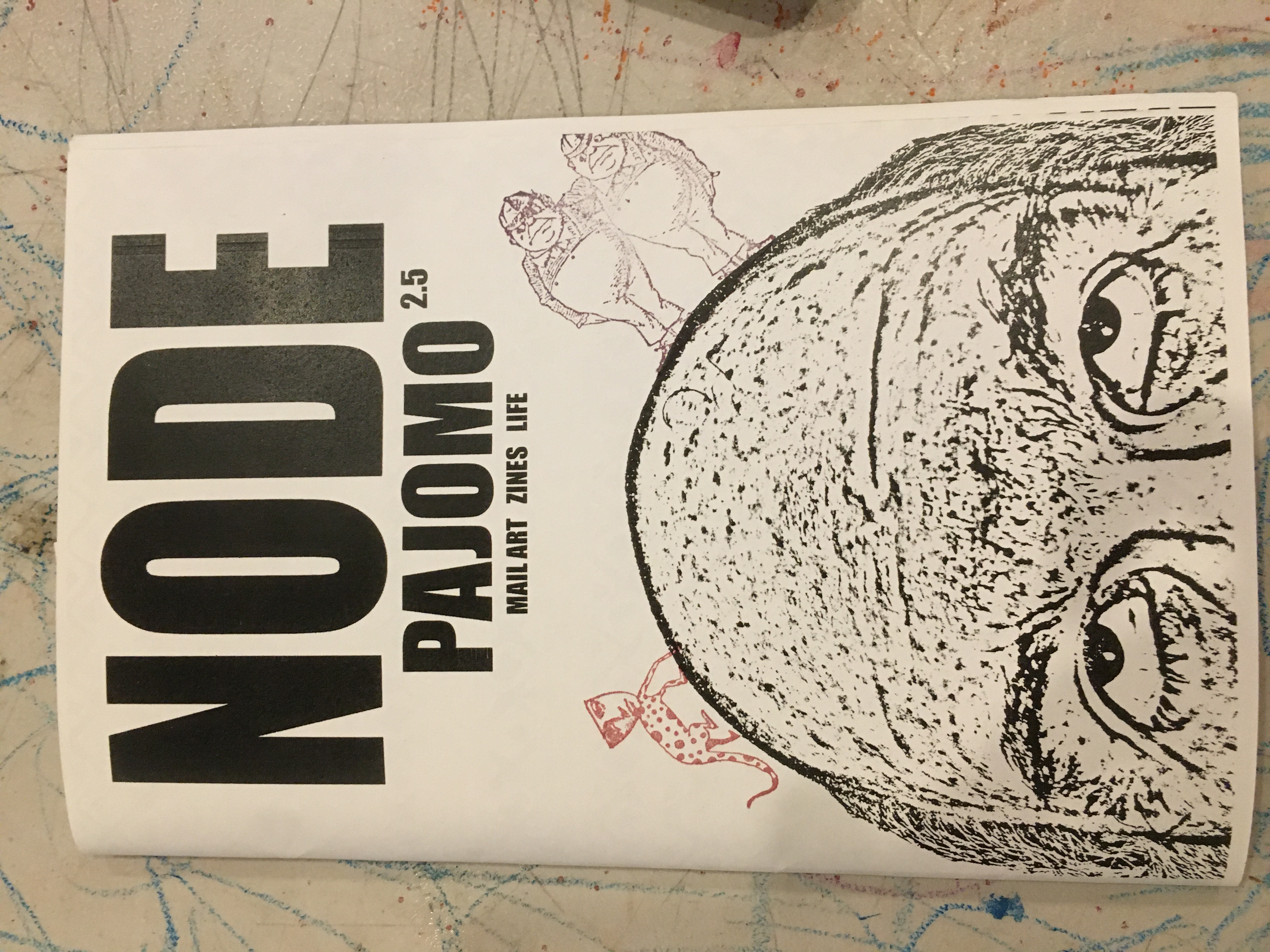 Black and white sketched image of the top half of a face. The head is bald, except for hair on the sides and the eyes are looking up. There are stamps of creatures on top of the head. 