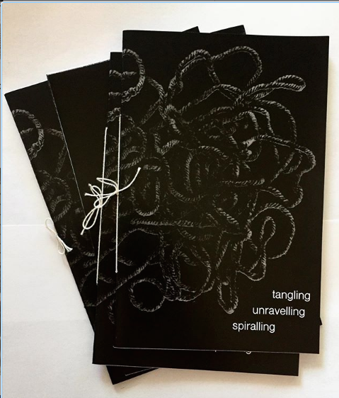 Image of 3 of the zines, layed out. the cover is black with a texture image of rope, with the title written in white. It is hand bound with white string. 