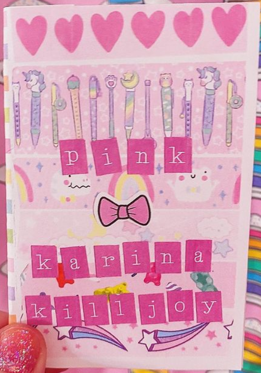 Pink patterned background of hearts, rainbows, and cute things with a pink bow in the middle and cutout letters saying "pink karina killjoy"