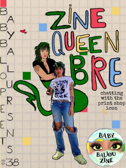 A woman with short dark hair in a t-shirt, ripped jeans, and crocs poses in front of an illustration of herself on a checkerboard background