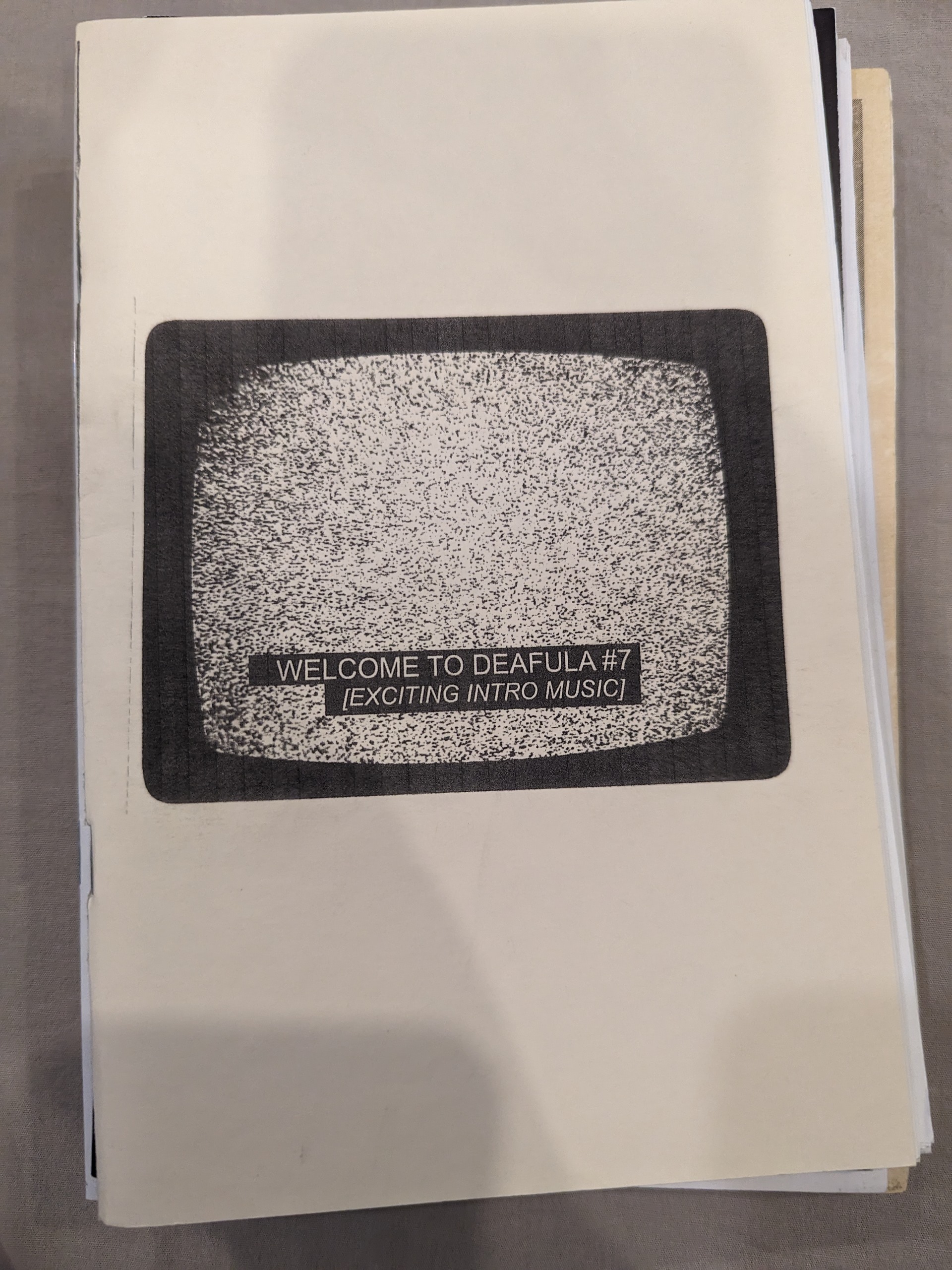 The cover is manilla with a old tv producing static in the center of the zine