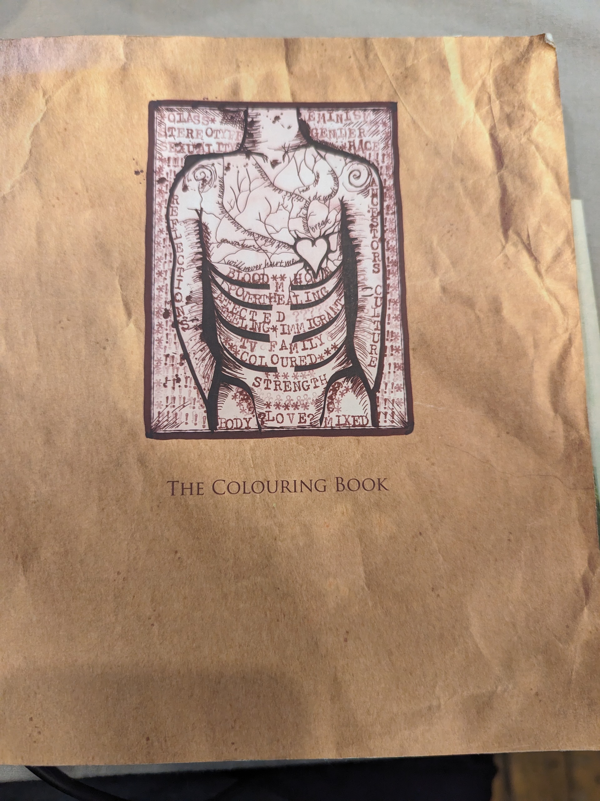 Crinkled up brown paper adorns the majority of the front page, along with drawn, partially dissected body. The white space surrounding the body is filled with words