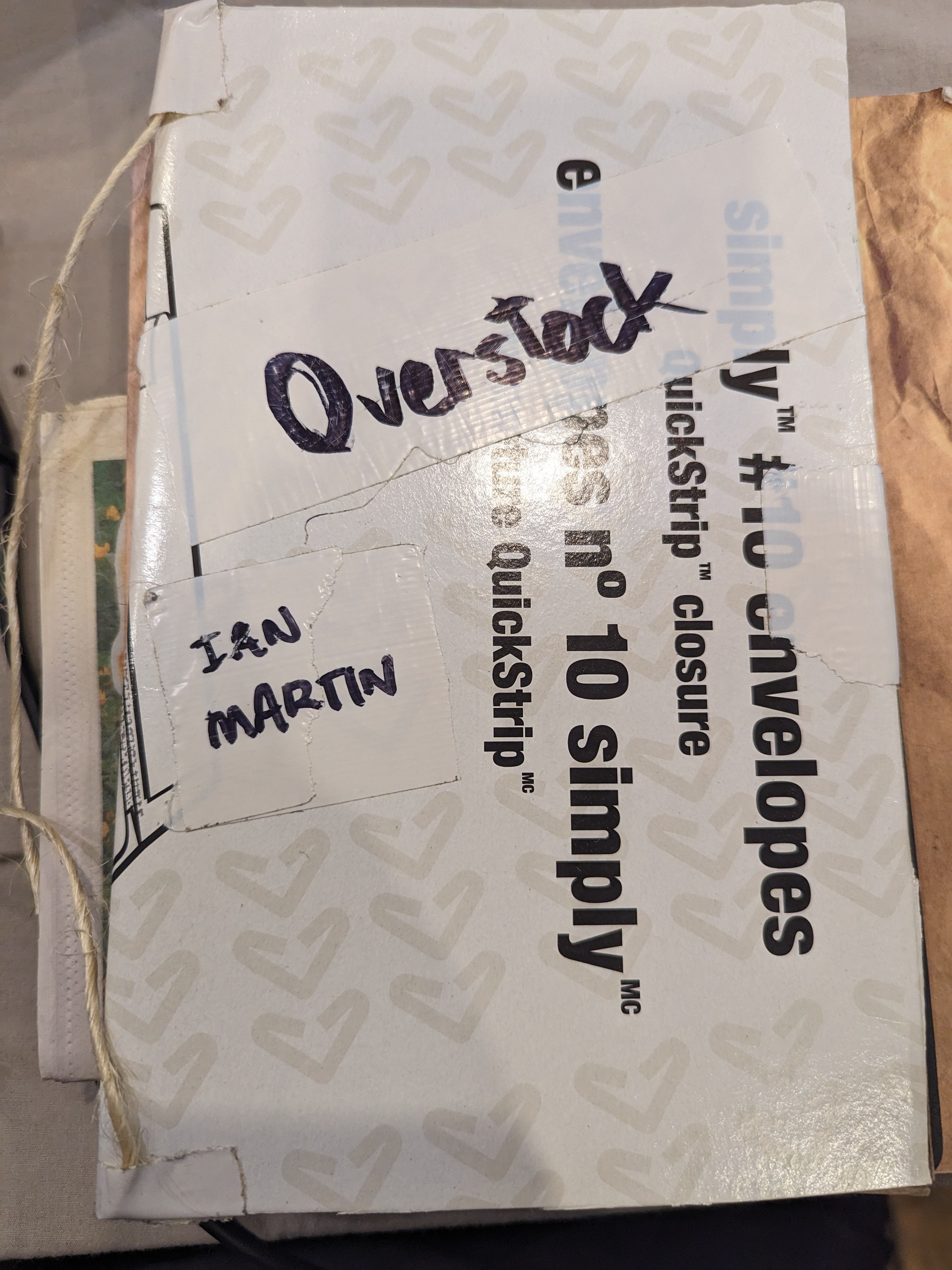 Recycled cardboard cover, title is written on ducktape, by a sharpie