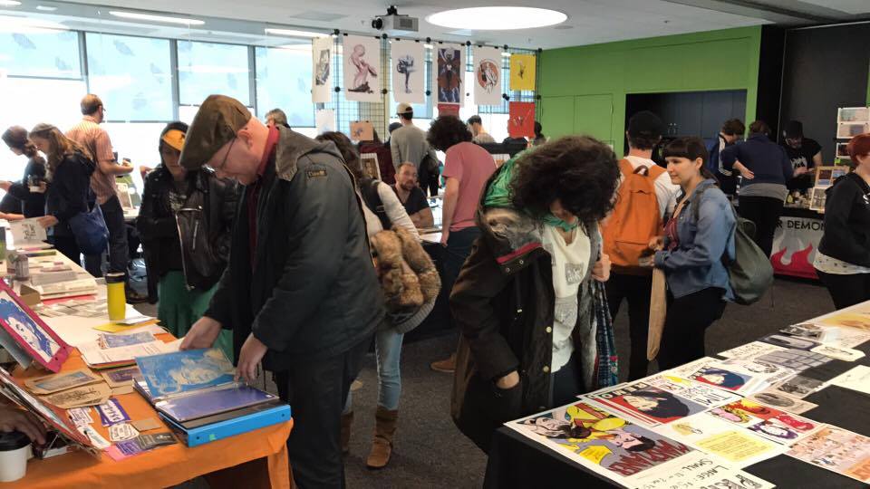 People looking at zines at the zine fair